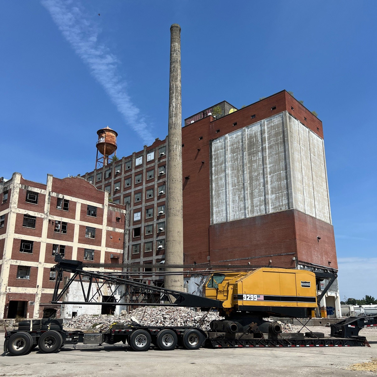 Huge crane arrives to begin demolition, starting with 160' tall smokestack.